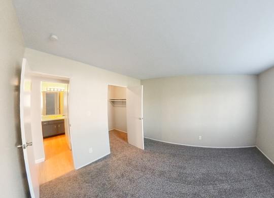 an empty room with a large window and a carpeted floor
