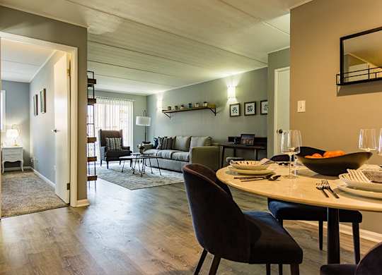 a living room and dining room with a table and chairs