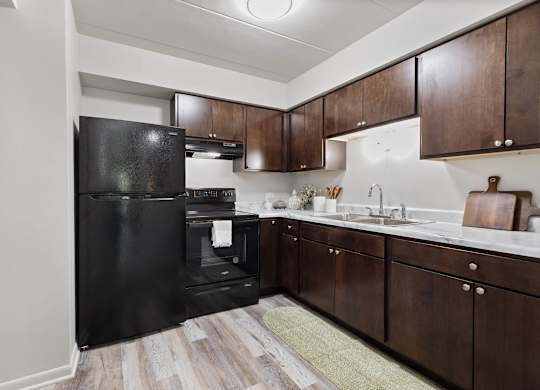 a kitchen with black appliances and wooden cabinets