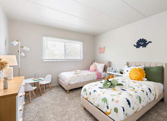 a bedroom with two twin beds and a desk