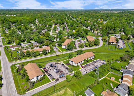 an aerial view of a neighborhood with houses and trees and a road