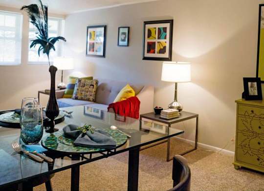 a living room with a glass table and a couch