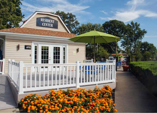 a white fence in front of a restaurant with an umbrella