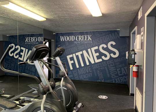 a spin bike in a gym with a wall that says fitness