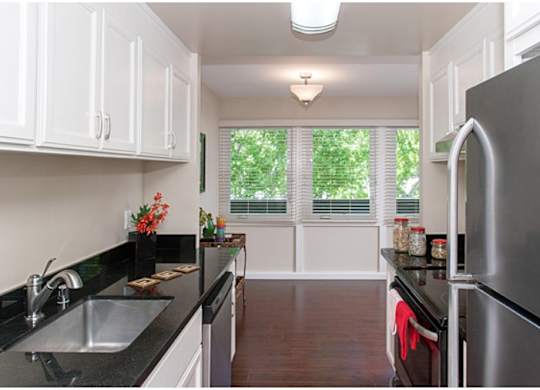 A kitchen with black countertops and white cabinets.