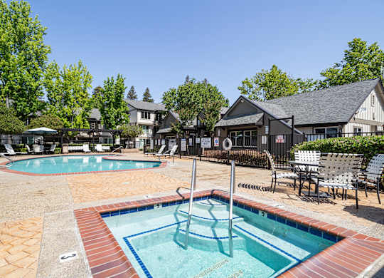 A pool with a slide and a hot tub.