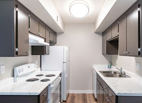A kitchen with a white stove top oven and a white refrigerator.