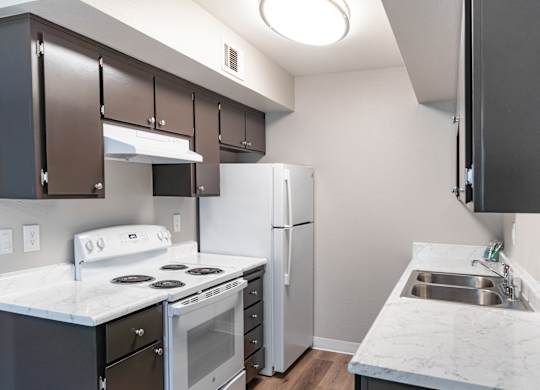 A kitchen with a white counter top and a white stove top oven.