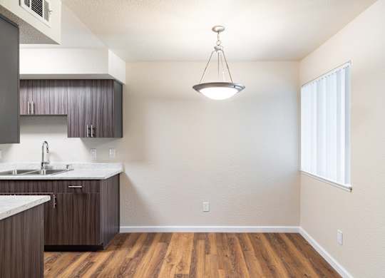 A kitchen with wooden floors and a white countertop.
