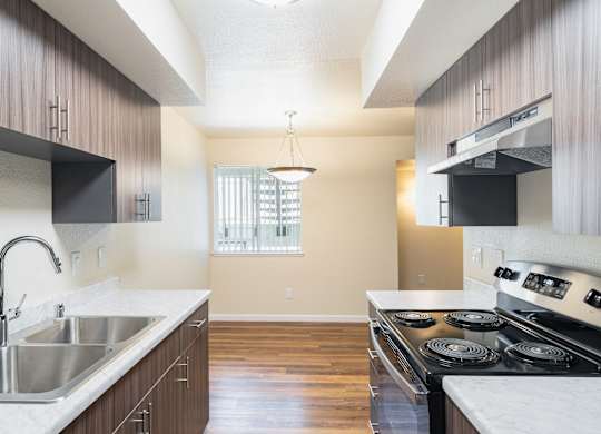 A kitchen with a stove top oven and a sink.