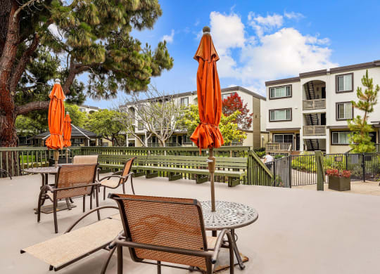 an outdoor patio with tables and chairs and umbrellas