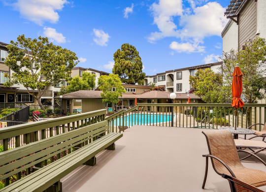 a patio with a pool and chairs and buildings