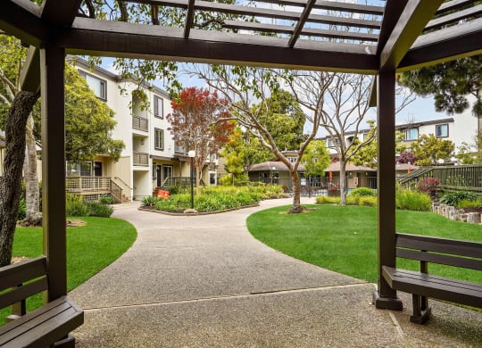 a view of a courtyard with benches and buildings
