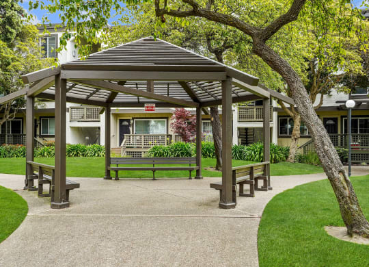 a park with a gazebo and benches in front of a building