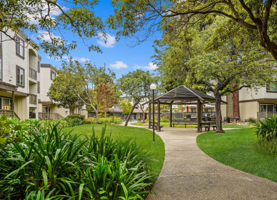 a park with a gazebo and trees in front of apartment buildings