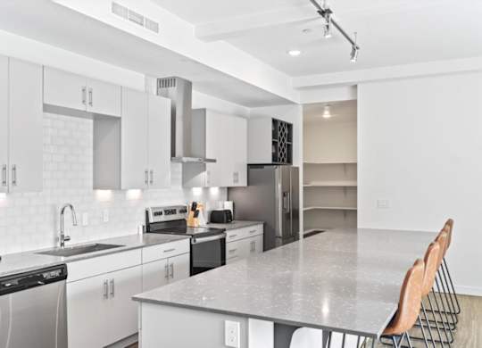 A modern kitchen with white cabinets and appliances. at Paperbox Lofts, Utah, 84101