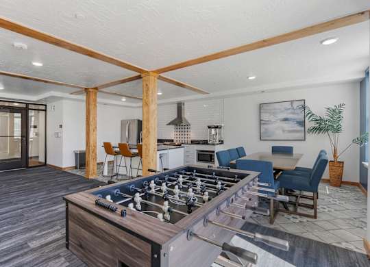 a family room with a foosball table and a kitchen with a dining area at City View St. George Apartments, St George