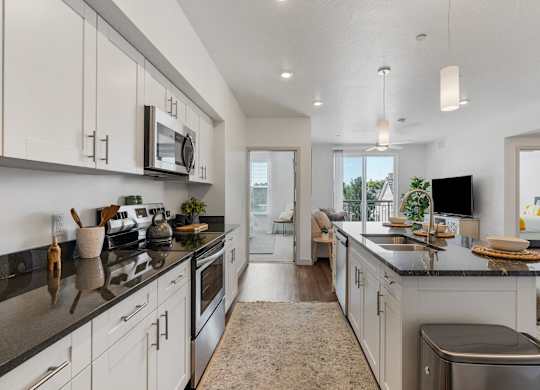 an open kitchen with white cabinets and a large counter top at City View St. George Apartments, Utah, 84770