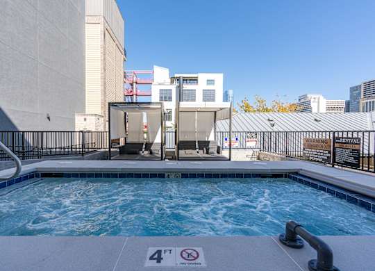 a swimming pool with a hot tub and a building in the background at The Revival, Utah, 84101