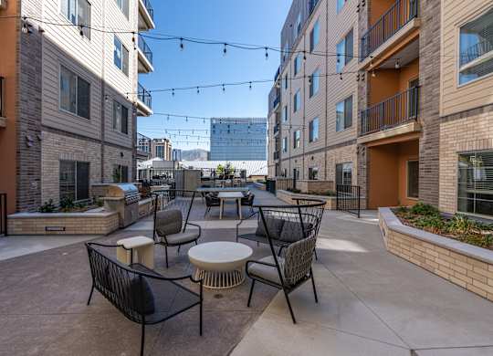 an outdoor patio area with tables and chairs and buildings at The Revival, Salt Lake City, 84101