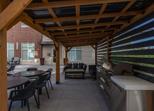 a covered patio with a grill and tables and chairs at 200 City View, Provo, UT, 84601
