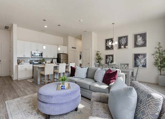 an open living room and kitchen with a couch and a table at 200 City View, Provo, 84601