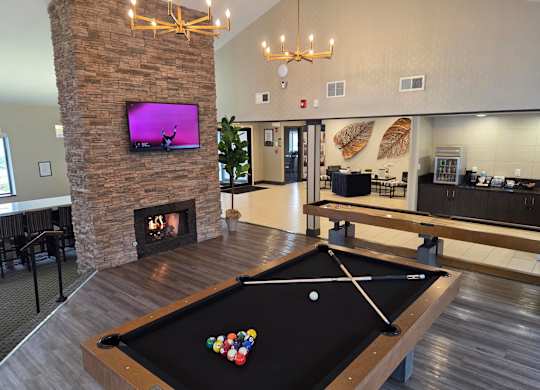 Pool table with a television with a fireplace at Avia Lofts at Maple Road, New York