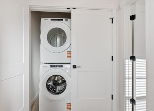 Small Laundry room with stacked washer and dryer at Alante Homes at Spring Run, Caldwell