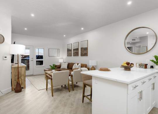A modern kitchen with white cabinets and a wooden island. at The Vue At Desert Color, St. George, 84790