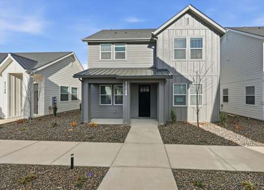 Modern house with a grey front yard at Alante Homes at Spring Run, Caldwell