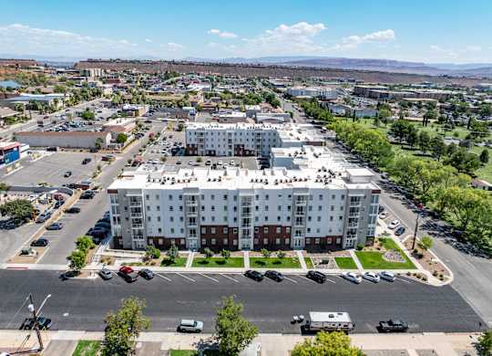 A large white building with a parking lot in front of it. 605 Place Student Housing & Co-Living, St George