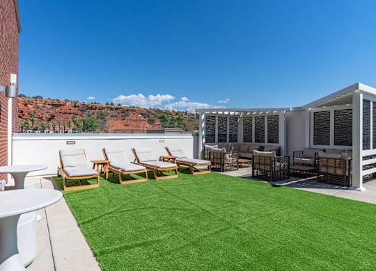 a yard with lawn chairs and a patio with a mountain in the background at 605 Place Student Housing & Co-Living, St George
