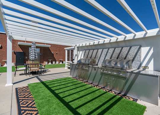 a covered patio with two bbq grills and grass at 605 Place Student Housing & Co-Living, St George