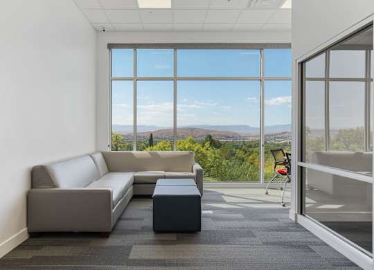 a living room with a couch and a coffee table in front of large windows at 605 Place Student Housing & Co-Living, St George