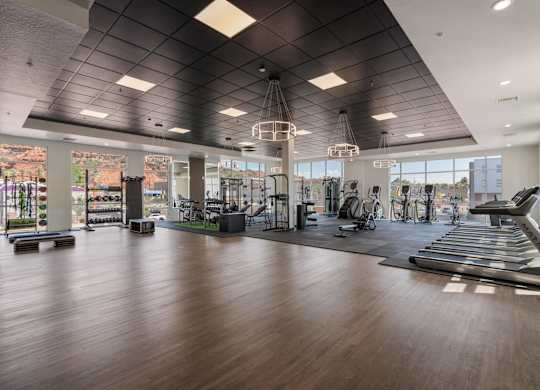 a gym with treadmills and other exercise equipment and windows at 605 Place Student Housing & Co-Living, St George, UT, 84770