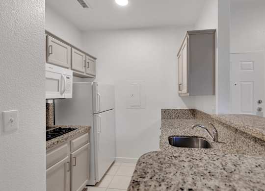 Kitchen with granite countertop at AVIA Apartments On Alpha, Dallas, TX, 75240