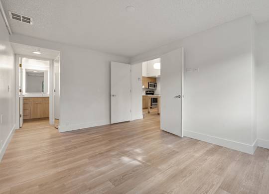 a living room and kitchen with wood floors and white walls at AVIA Lofts on Parkway Apartments, Washington, 98662