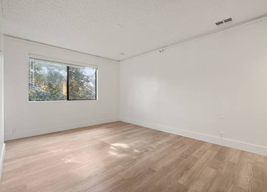 a spacious living room with wood floors and a window at AVIA Lofts on Parkway Apartments, Vancouver, WA