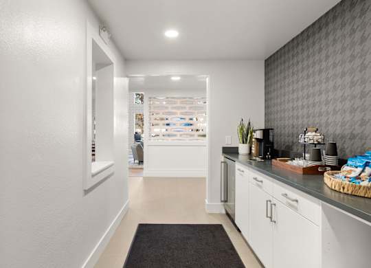 a kitchen with white cabinets and a counter top and a door to a store at AVIA Lofts on Parkway Apartments, Vancouver, 98662