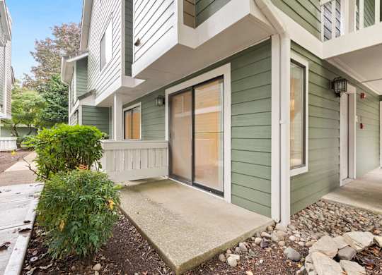 the entrance to a green house with a sidewalk and a glass door at AVIA Lofts on Parkway Apartments, Washington