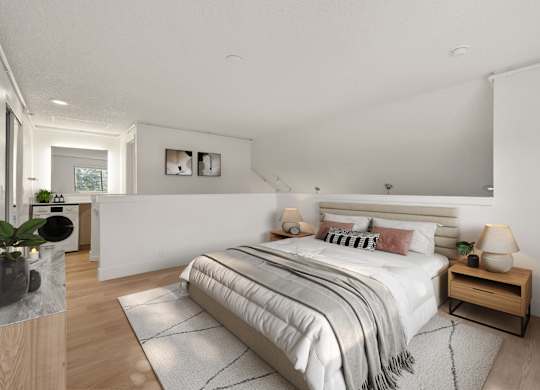A bedroom with a large bed and a wooden nightstand. at AVIA Lofts on Parkway Apartments, Vancouver, WA