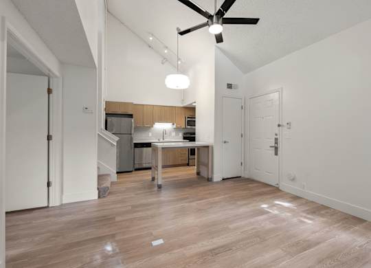 an empty living room and kitchen with a ceiling fan at AVIA Lofts on Parkway Apartments, Vancouver, Washington