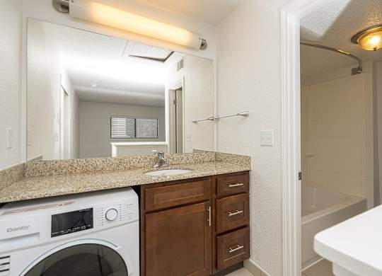 Bathroom with a sink and a washer and dryer at AVIA Lofts on Victors Way, Michigan , 48108