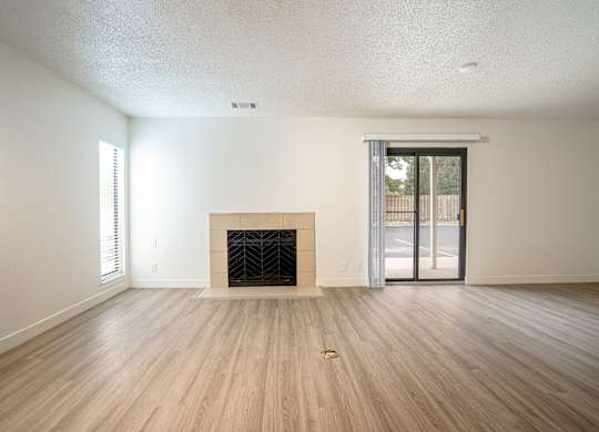 Living room with a fireplace and sliding glass doors at AVIA Lofts on Victors Way, Ann Arbor, 48108