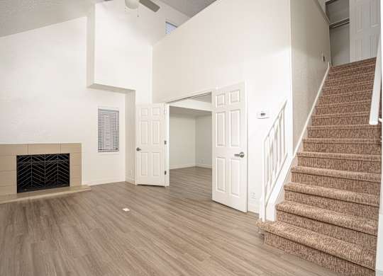Grey carpeted staircase and a fireplace at AVIA Lofts on Victors Way, Ann Arbor, MI, 48108