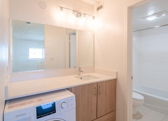Bathroom with a washer and dryer at Avia Lofts at Maple Road, Amherst