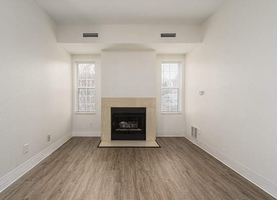 Living room with a fireplace and wooden floors at AVIA Lofts on Victors Way, Ann Arbor, Michigan