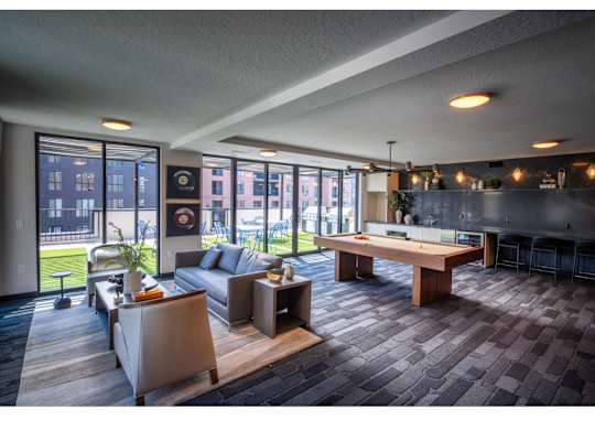 A modern living room with a pool table and a view of the city.
