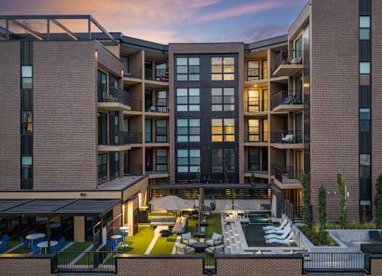 A modern apartment complex with a courtyard and outdoor seating area.