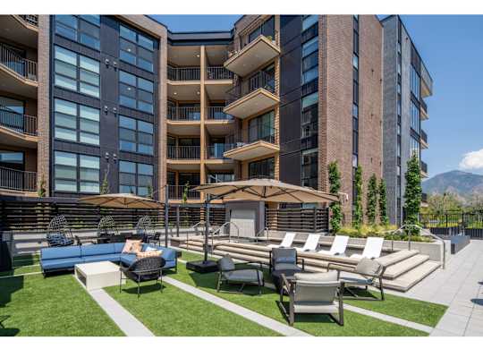 A modern apartment complex with a well-maintained outdoor seating area.